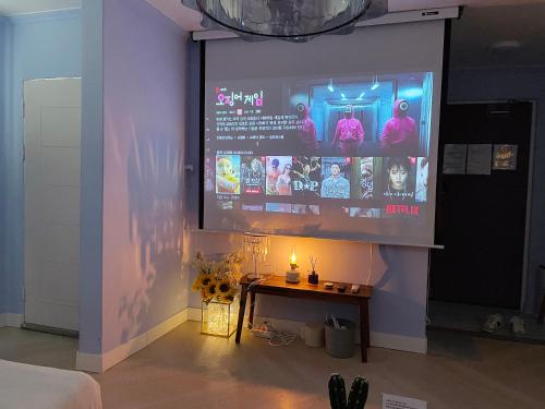 a room with a table and a large screen at Hostel Mihojae Seomyeon in Busan