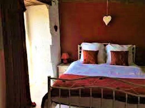 a bedroom with a bed with red and white pillows at Gites la Charrue in Monsec