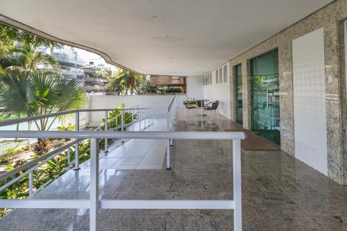 un balcón interior con barandilla blanca y árboles en Pé Na Areia Recreio, en Río de Janeiro