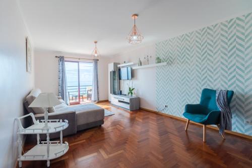 a living room with a couch and a chair at Calandiva in Caniço