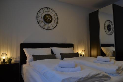um quarto com duas camas e um relógio na parede em Apartment mit Terrasse und eigenem Eingang em Radevormwald