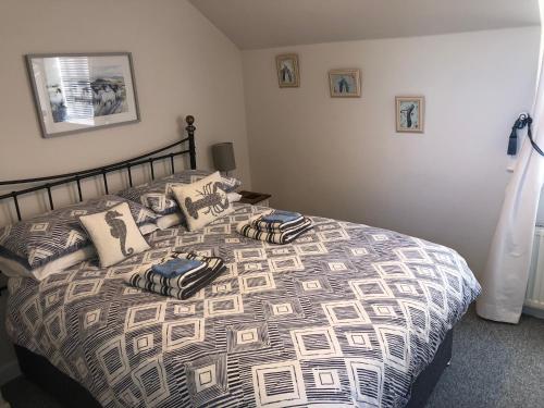 Un dormitorio con una cama con almohadas. en Pixie Cottage en Eastbourne