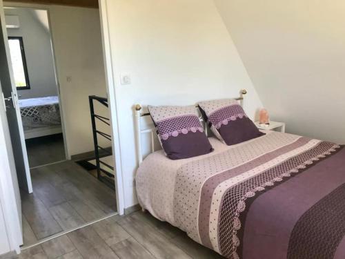 sypialnia z łóżkiem z fioletową pościelą i poduszkami w obiekcie Villa La Baronne-Hauteurs de Beaulieu-sur-Dordogne w mieście Beaulieu-sur-Dordogne