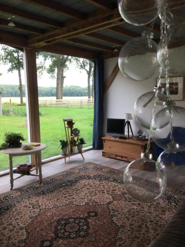 a living room with a large window and a table at Koetshuis in Veenhuizen