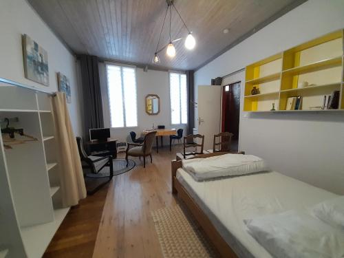 1 dormitorio con cama y escritorio. en Résidence Les Volets Bleus: Studio de 30 m² classé 2 *, en Rochefort