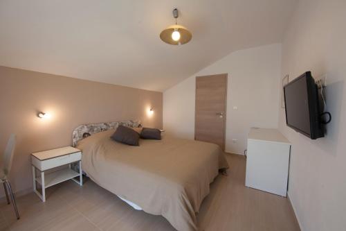 a bedroom with a bed and a flat screen tv at Wellness Villa Istriana in Umag