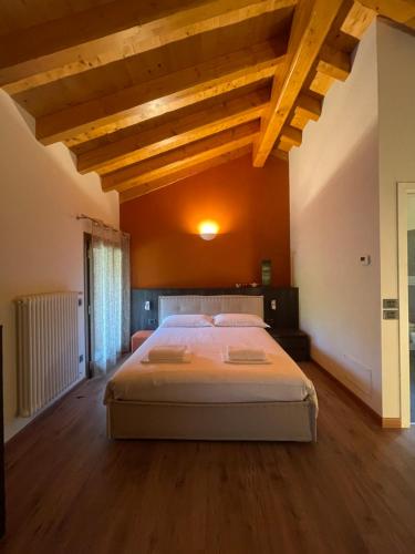 a bedroom with a large bed in a room with wooden ceilings at Casa vacanze Campone in Campone