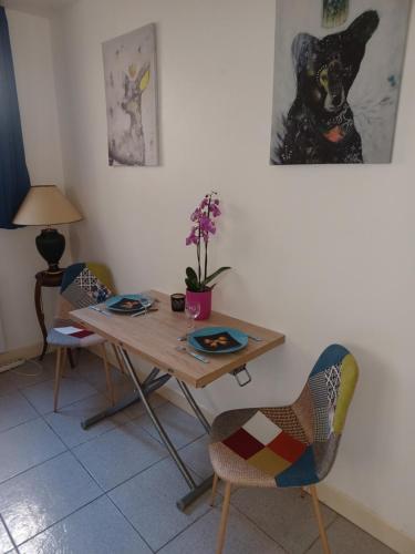 une table et des chaises dans une pièce avec une table et un tableau dans l'établissement Le Senlipin, studio centre ville, coeur de Senlis, proche parc Asterix, à Senlis