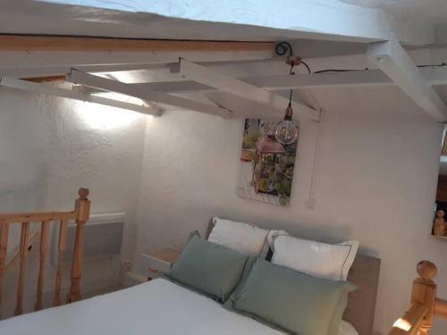 una camera da letto con letto, cuscini e soffitto di Garden Annexe 2 a Villeneuve-Loubet