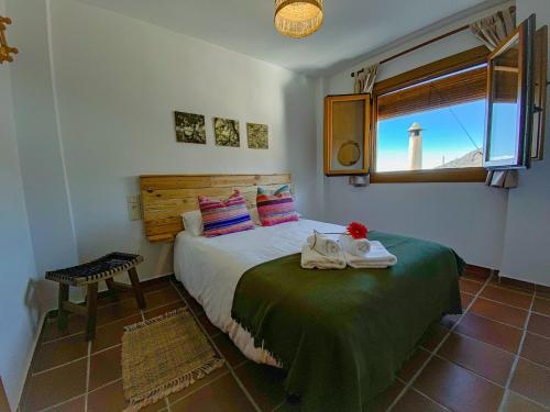 a bedroom with a bed and a window with a lighthouse at La Higuera in Bubión