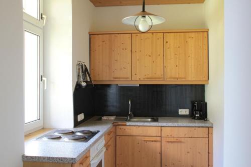 una cocina con armarios de madera y fregadero en Villa Pranter, en Sillian