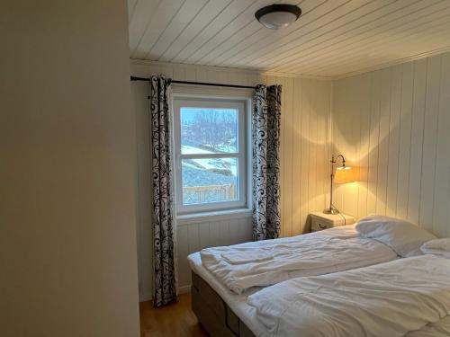 a bedroom with a bed and a window at Vesterålen Kysthotell in Stokmarknes