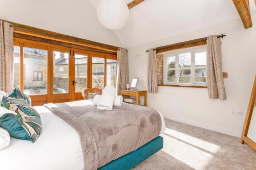 a bedroom with a large bed and windows at 1 Homepiece in Chipping Campden