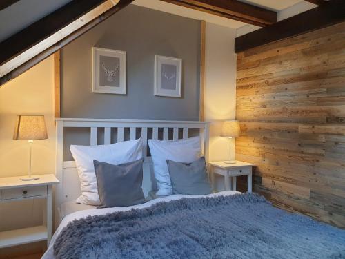a bedroom with a bed with a wooden wall at Ferienhaus Chiemgauer Auszeit- Chiemgaukarte inclusive in Siegsdorf