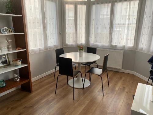 a table and chairs in a room with windows at Les vagues, villa avec garage in Wimereux