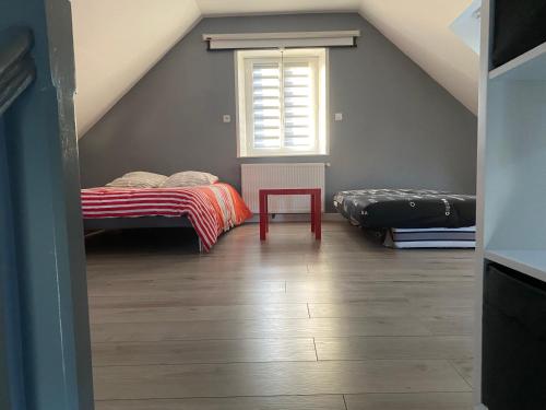a attic room with two beds and a red table at Les vagues, villa avec garage in Wimereux
