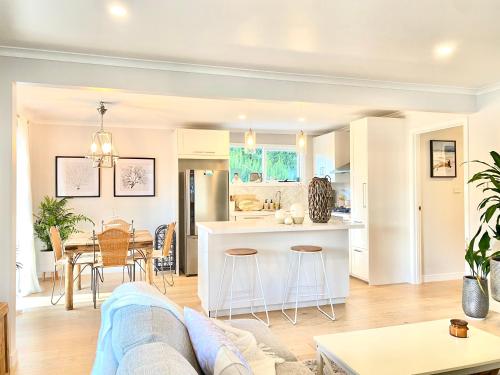 un soggiorno e una cucina con un divano e un tavolo di Rosebud Lovely House - Mornington Peninsula 3 BR holiday house - Jacuzzi - BBQ - Basketball ring - Beach - Hot springs a Rosebud