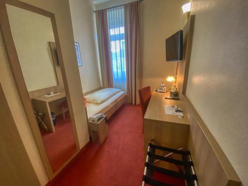 a hotel room with a bed and a mirror at City Partner Hotel Berliner Hof in Karlsruhe
