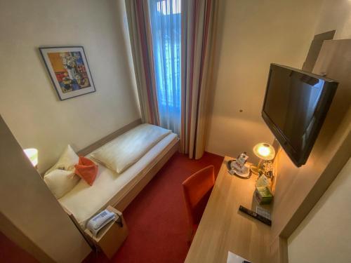 a hotel room with a bed and a television at City Partner Hotel Berliner Hof in Karlsruhe