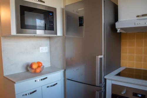 - une cuisine avec un bol d'oranges et un four micro-ondes dans l'établissement Joli appartement F3 - 50m de la mer, à Cabourg