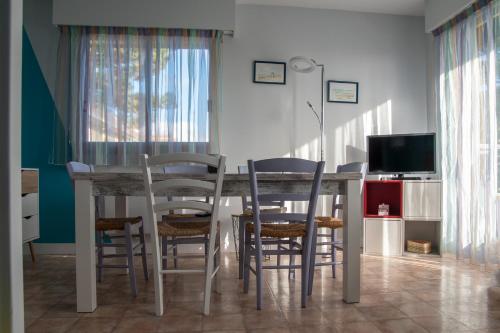 une cuisine avec une table et des chaises ainsi qu'une télévision dans l'établissement Joli appartement F3 - 50m de la mer, à Cabourg