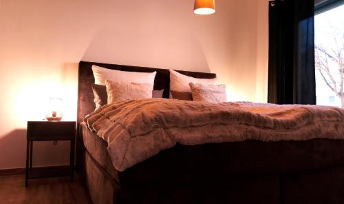 1 dormitorio con cama con almohadas y ventana en Select-Home 2 - Netflix - Kaffee&Tee - Parkplatz - viele Extras, en Bruck in der Oberpfalz