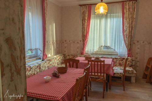 a dining room with two tables and two windows at Agroturystyka Nad Jeziorem-Osada Indiańska in Czchów