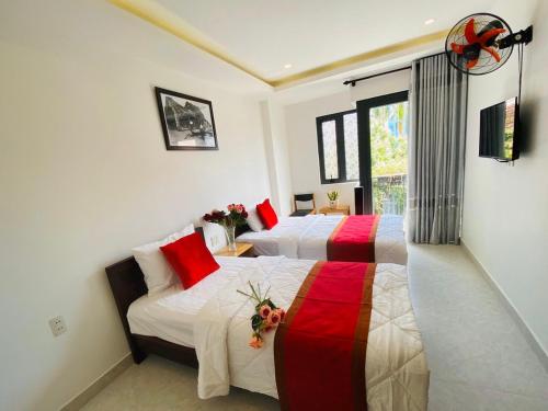 um quarto de hotel com duas camas e uma janela em Toro Homestay em Hoi An