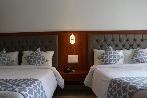 a hotel room with two beds and a headboard at La Vera Boutique Hotel, Mandrem in Mandrem