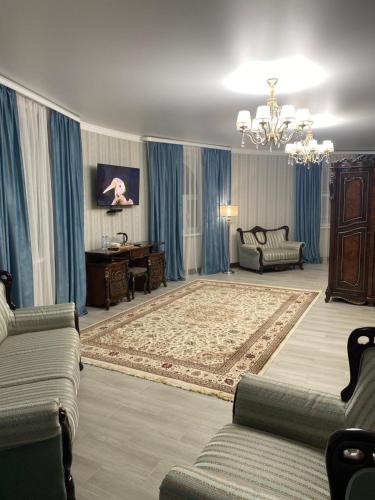a large living room with blue curtains and a couch at Hotel Astam in Kostanay