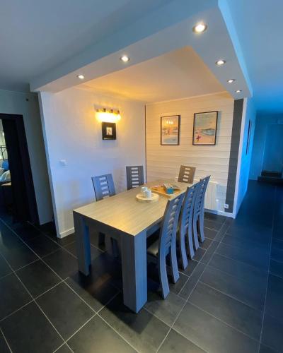 une salle à manger avec une table et des chaises en bois dans l'établissement Appartement en entrée de ville avec balneo, à Pont-lʼAbbé