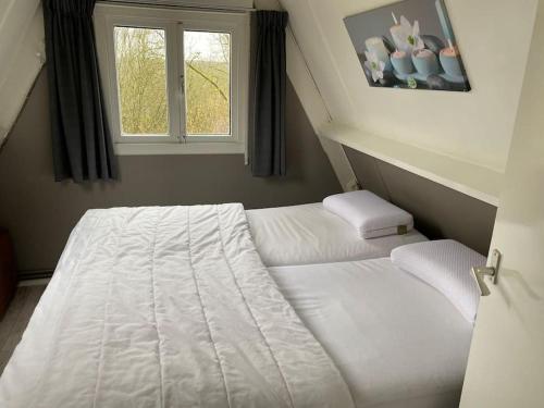 a white bed in a room with a window at Vakantiehuis Durbuy 'De witte vlinder' in Durbuy