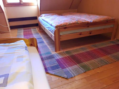 a bedroom with two beds and a rug at U včelárov in Mýto pod Ďumbierom