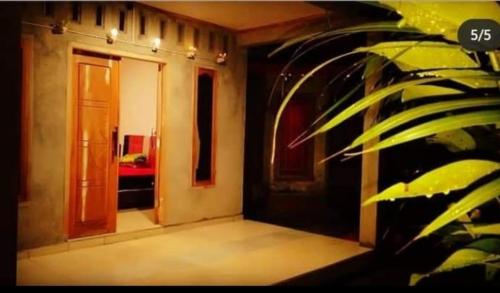 a hallway of a house with a door and a plant at Eltari Homestay in Tetebatu