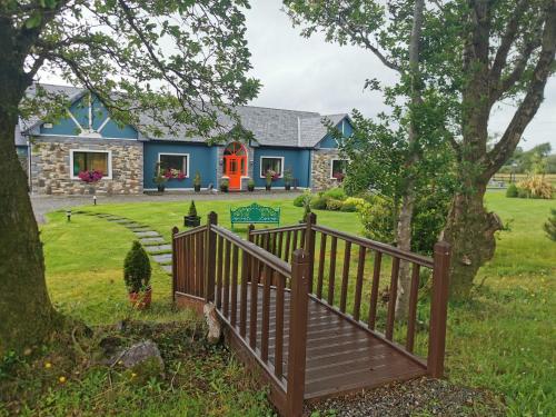 uma casa azul com uma cerca de madeira em frente em The Ferris Wheel B&B em Beaufort