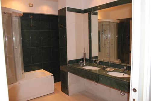 a bathroom with two sinks and a bath tub at Aretusa Palace Hotel in Syracuse