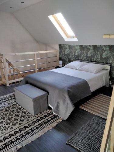 ein Schlafzimmer mit einem großen Bett und einem Dachfenster in der Unterkunft Chez Do.. in Beinheim
