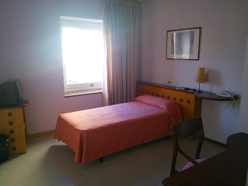 a bedroom with a bed and a window at Hotel Montmeló in Montmeló