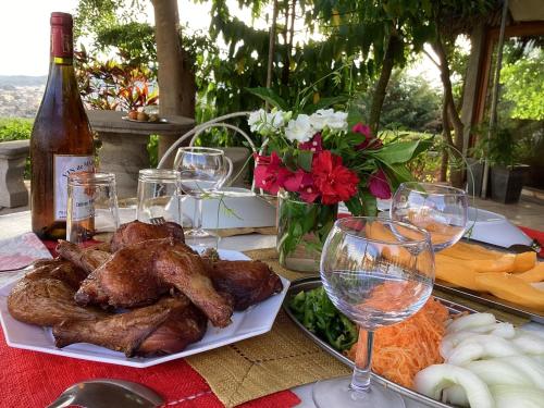 a table with a plate of food and wine glasses at Villa ChezSoa, Antananarivo in Antananarivo