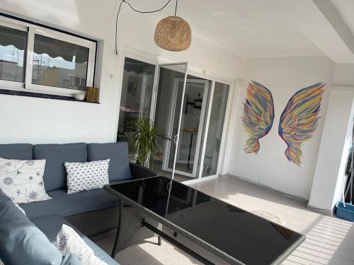 sala de estar con sofá azul y mesa de cristal en Sunny 3 bed beach flat - large terrace with sea view en Puerto de Sagunto
