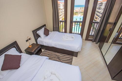 Cette chambre dispose de deux lits et d'un balcon. dans l'établissement Premium sea view 2 bedrooms 2 bathrooms apartment located within Gravity Hotel & Aquapark Hurghada, à Hurghada