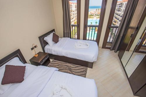 een hotelkamer met twee bedden en een balkon bij Premium sea view 2 bedrooms 2 bathrooms apartment located within Gravity Hotel & Aquapark Hurghada in Hurghada