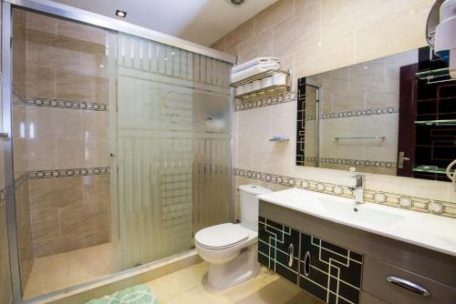 een badkamer met toilet, wastafel en douche bij Premium sea view 2 bedrooms 2 bathrooms apartment located within Gravity Hotel & Aquapark Hurghada in Hurghada