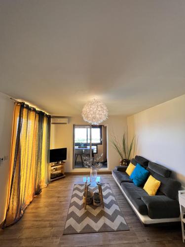 a living room with a couch and a chandelier at Sea View & More… in Saint-Denis
