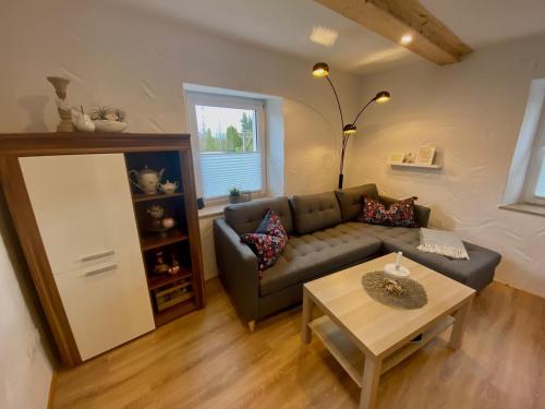 uma sala de estar com um sofá e uma mesa em Ferienhaus Göbel´s gute Stube em Wirfus