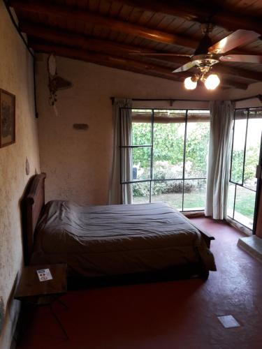 a bedroom with a bed and a large window at Flor de las Sierras in Capilla del Monte