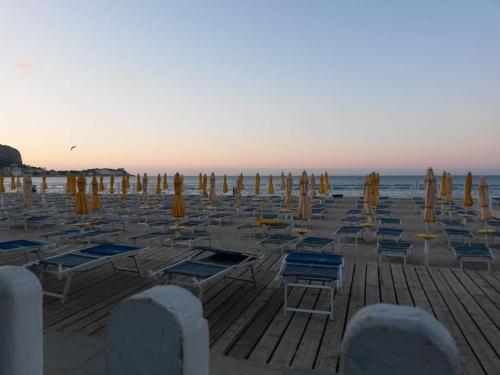 a group of chairs and umbrellas on a beach at Le Vele Mondello, villa a due passi dal mare in Mondello
