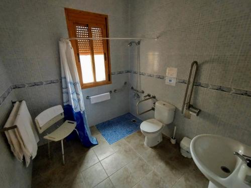 baño con aseo y lavabo y ventana en Cortijo La Estrella, en Vélez Rubio