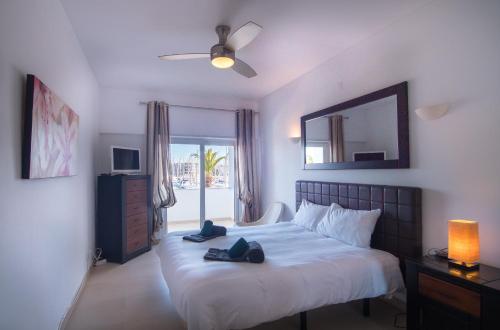 a bedroom with a bed with a mirror and a window at Lagos Marina view apartment near beaches and shops in Lagos