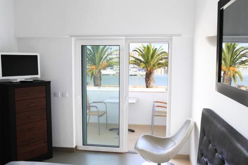 a bedroom with a sliding glass door with a view of the ocean at Lagos Marina view apartment near beaches and shops in Lagos